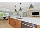 Kitchen island with a white countertop and wood cabinets, open to the dining and living areas at 1208 Oak Hammock Rd, Sarasota, FL 34240