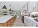 Open kitchen featuring a large island, white cabinetry, and wood floors, with views to the living room at 1208 Oak Hammock Rd, Sarasota, FL 34240