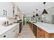 Bright kitchen with a long island, white cabinetry, and wood flooring leading to dining area at 1208 Oak Hammock Rd, Sarasota, FL 34240
