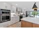 Kitchen with modern appliances, white cabinetry, and an island bar for additional seating at 1208 Oak Hammock Rd, Sarasota, FL 34240