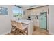 Cozy kitchenette with white cabinets, marble countertops, a unique retro refrigerator, and counter seating at 1208 Oak Hammock Rd, Sarasota, FL 34240