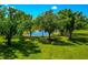 Picturesque view of a pond framed by lush trees and verdant grass, creating a serene and inviting outdoor space at 1208 Oak Hammock Rd, Sarasota, FL 34240