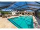 Screened pool with stone surround, lounge seating and mature trees offers a private outdoor oasis at 1208 Oak Hammock Rd, Sarasota, FL 34240