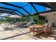 Beautiful covered patio features lounge chairs, dining table, outdoor lighting, and picturesque views at 1208 Oak Hammock Rd, Sarasota, FL 34240