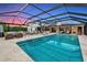 Relaxing screened pool with lounge chairs, outdoor dining and mature landscaping at 1208 Oak Hammock Rd, Sarasota, FL 34240