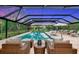 Covered pool with outdoor lounge seating and a clear view of the backyard sunset at 1208 Oak Hammock Rd, Sarasota, FL 34240