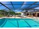 Beautiful backyard with a screened-in pool, lounge area, dining area, and scenic views at 1208 Oak Hammock Rd, Sarasota, FL 34240