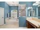 Bright bathroom features a soaking tub, walk-in shower, and blue accent wall at 12810 Kite Dr, Bradenton, FL 34212