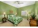 Bedroom with green walls, a ceiling fan, and a quaint sitting area at 12810 Kite Dr, Bradenton, FL 34212