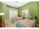 Bright, green bedroom with twin beds, neutral carpet, and a closet for storage at 12810 Kite Dr, Bradenton, FL 34212