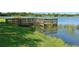 Charming wooden dock on the lake with clear reflections and grassy shoreline for outdoor enjoyment at 12810 Kite Dr, Bradenton, FL 34212