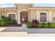 Inviting front entrance with columns, an arched entryway, and lush landscaping at 12810 Kite Dr, Bradenton, FL 34212