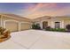 Stunning home exterior featuring a three-car garage and lush landscaping at 12810 Kite Dr, Bradenton, FL 34212