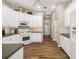 Functional kitchen features white cabinetry, laminate flooring, and convenient access to hallway at 12810 Kite Dr, Bradenton, FL 34212