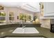 Kitchen sink with green countertop overlooks the outdoor space with pool at 12810 Kite Dr, Bradenton, FL 34212