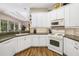Well-lit kitchen boasts white cabinets, modern appliances, and breakfast bar at 12810 Kite Dr, Bradenton, FL 34212