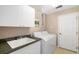 Laundry room featuring a sink, white cabinets, a window, and a washer and dryer at 12810 Kite Dr, Bradenton, FL 34212