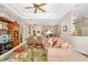 Bright living room with tray ceiling, neutral walls, floral rug and comfortable seating at 12810 Kite Dr, Bradenton, FL 34212