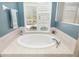 Main bathroom featuring a luxurious soaking tub with tile surround and natural light at 12810 Kite Dr, Bradenton, FL 34212