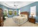 Serene main bedroom with tray ceiling, ceiling fan, and abundant natural light at 12810 Kite Dr, Bradenton, FL 34212