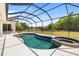 Screened pool with attached spa overlooking a lush green backyard and pond at 12810 Kite Dr, Bradenton, FL 34212