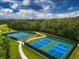 Aerial view of blue and green community tennis courts surrounded by lush greenery at 12810 Kite Dr, Bradenton, FL 34212