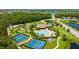 Aerial view showcasing the community's amenities: pool, tennis courts, playground and lush green spaces at 12822 Kite Dr, Bradenton, FL 34212