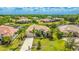 Beautifully landscaped home with a well-manicured lawn and a tile roof is surrounded by mature trees at 12822 Kite Dr, Bradenton, FL 34212