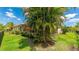 Green backyard with a well-manicured lawn, tropical plants, and a glimpse of the screened-in patio, fenced for privacy at 12822 Kite Dr, Bradenton, FL 34212