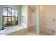 Bright bathroom features a soaking tub under an arched window and glass shower at 12822 Kite Dr, Bradenton, FL 34212