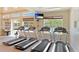 Bright fitness center with treadmills, mounted TV, and large windows at 12822 Kite Dr, Bradenton, FL 34212