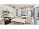 Bright kitchen features white cabinetry, stainless steel appliances, and an island with a quartz countertop at 12822 Kite Dr, Bradenton, FL 34212