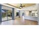 Open-concept living room featuring tile floors and sliding glass doors with curtains at 12822 Kite Dr, Bradenton, FL 34212