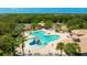 Aerial shot of the community pool featuring a playful splash area, surrounded by lounge chairs and lush landscaping at 12822 Kite Dr, Bradenton, FL 34212