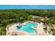 Birds-eye view of a community pool featuring a splash area, pool furniture, and surrounding greenery at 12822 Kite Dr, Bradenton, FL 34212