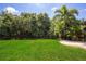 Expansive backyard featuring lush greenery, a palm tree, and a secure black fence for added privacy at 12841 Balsam Ter, Bradenton, FL 34212