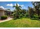Lush backyard featuring a well-manicured lawn, mature landscaping, and a screened-in lanai perfect for outdoor entertaining at 12841 Balsam Ter, Bradenton, FL 34212