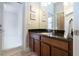 Well-lit bathroom featuring a dark granite countertop, wood cabinets, and decorative seashell wall art at 12841 Balsam Ter, Bradenton, FL 34212