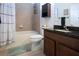 Bathroom featuring tiled walls, dark wood cabinets, a toilet, bathtub, and practical storage at 12841 Balsam Ter, Bradenton, FL 34212