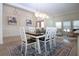 Dining room with white and wood table, seating for six, and stylish pendant lights at 12841 Balsam Ter, Bradenton, FL 34212