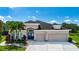 Stunning home featuring a three-car garage, beautiful landscaping, and a welcoming front entrance with palm trees at 12841 Balsam Ter, Bradenton, FL 34212
