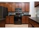 A modern kitchen with stainless steel appliances, granite countertops, and wood cabinets at 12841 Balsam Ter, Bradenton, FL 34212