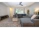 Spacious living room featuring a sectional sofa, ceiling fan, and natural light at 12841 Balsam Ter, Bradenton, FL 34212