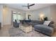 Comfortable living room with large sectional sofa, ceiling fan, and sliding glass doors at 12841 Balsam Ter, Bradenton, FL 34212