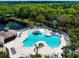 Aerial view of a resort-style pool area featuring a unique shape, water slide, and ample seating for relaxation at 12841 Balsam Ter, Bradenton, FL 34212