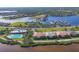 Aerial view of waterfront properties, community pool, marina, and tennis courts at 1294 Riverscape St # D, Bradenton, FL 34208