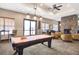 A recreational game room offering a pool table, comfortable seating, and a stone fireplace for residents at 1294 Riverscape St # D, Bradenton, FL 34208