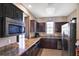 A well-equipped kitchen featuring dark cabinetry, granite countertops, and stainless steel appliances at 1294 Riverscape St # D, Bradenton, FL 34208