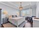 Comfortable main bedroom featuring a tray ceiling, decorative lighting, and a water view at 1294 Riverscape St # D, Bradenton, FL 34208