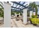 An inviting outdoor kitchen featuring a built-in grill, fireplace, and comfortable seating under a pergola at 1294 Riverscape St # D, Bradenton, FL 34208